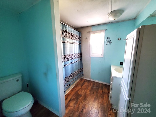 bathroom featuring toilet, vanity, and hardwood / wood-style floors