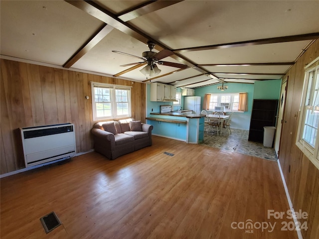 unfurnished living room featuring lofted ceiling with beams, wooden walls, wood-type flooring, and ceiling fan