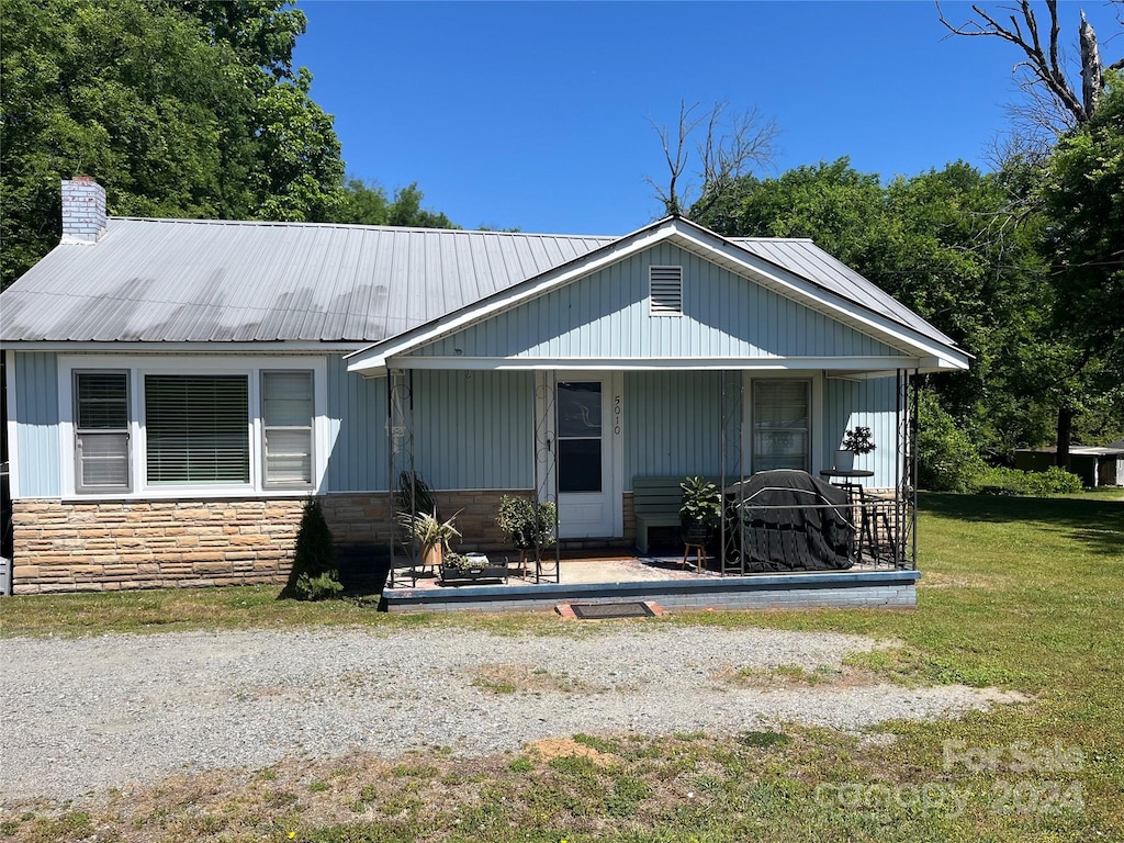 exterior space with a porch and a front yard