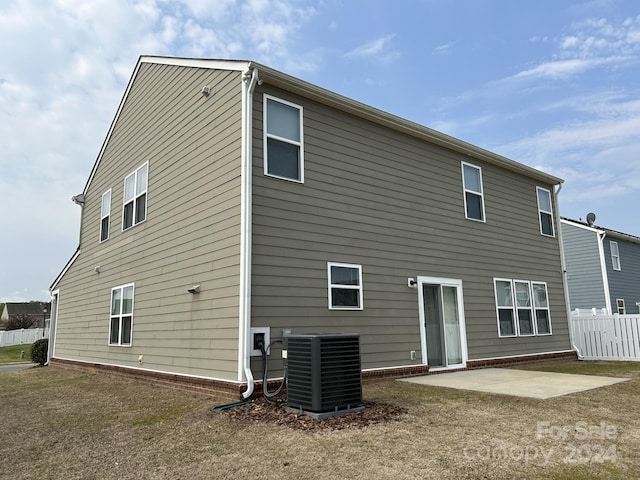 rear view of house featuring a yard, a patio, and central AC unit