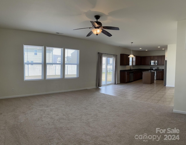 unfurnished living room featuring ceiling fan and light tile floors