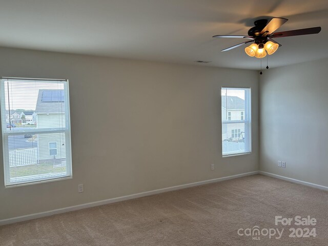 empty room with ceiling fan and light colored carpet