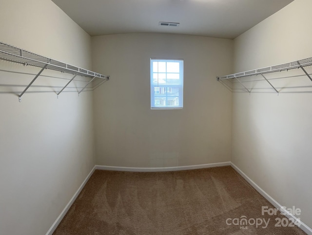 spacious closet featuring dark colored carpet