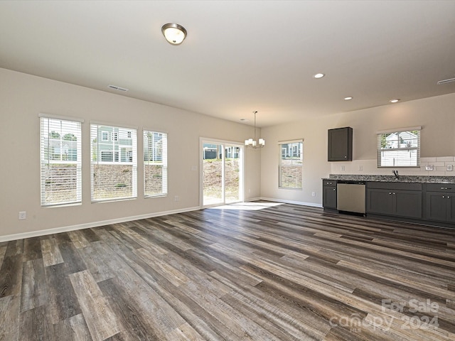 unfurnished living room with sink, dark hardwood / wood-style flooring, and an inviting chandelier