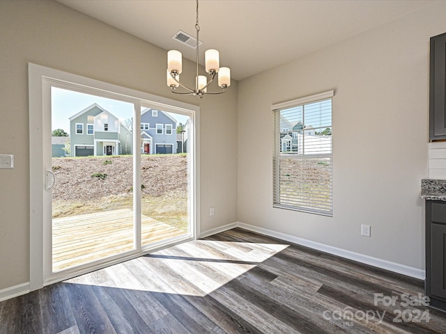 unfurnished dining area featuring a notable chandelier and dark hardwood / wood-style floors