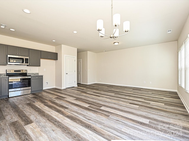 kitchen featuring dark wood-type flooring, appliances with stainless steel finishes, decorative light fixtures, and gray cabinetry