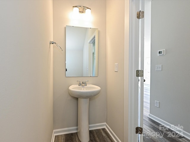 bathroom featuring a sink, baseboards, and wood finished floors