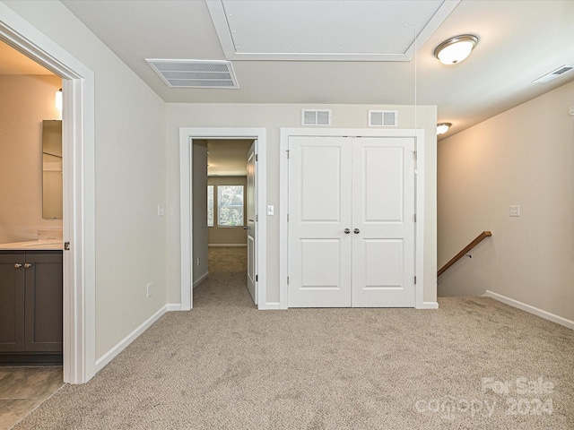 unfurnished bedroom featuring attic access and visible vents