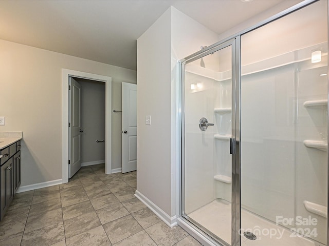 full bathroom featuring a shower stall, baseboards, and vanity