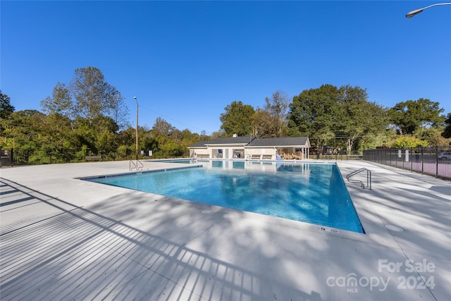 community pool with fence and a patio