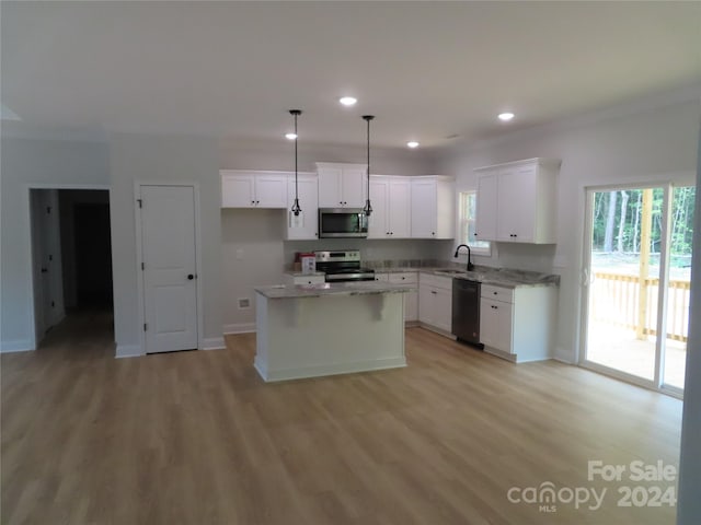 kitchen with a kitchen island, pendant lighting, sink, appliances with stainless steel finishes, and white cabinets