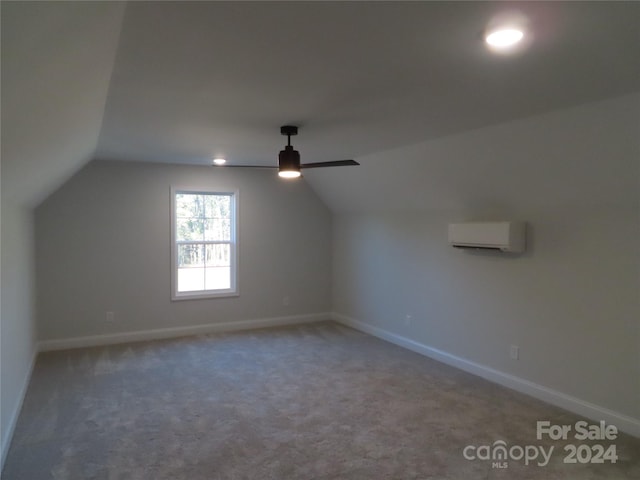 additional living space with lofted ceiling, an AC wall unit, carpet floors, and ceiling fan