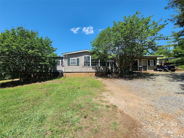 view of front of house featuring a carport and a front lawn