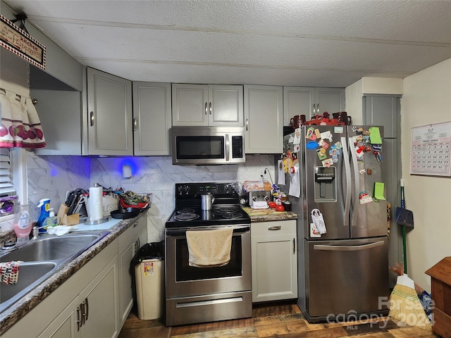 kitchen with backsplash, sink, stainless steel appliances, and dark hardwood / wood-style flooring