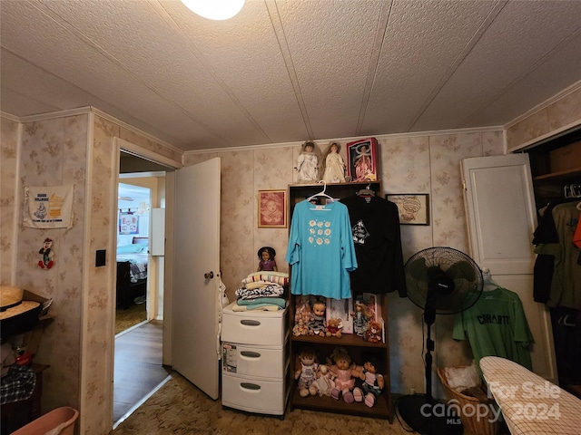 interior space featuring a textured ceiling, hardwood / wood-style flooring, and ornamental molding