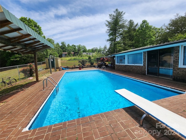 view of pool featuring a diving board and a patio area