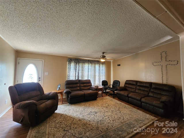 living room with wood-type flooring, ceiling fan, and a textured ceiling