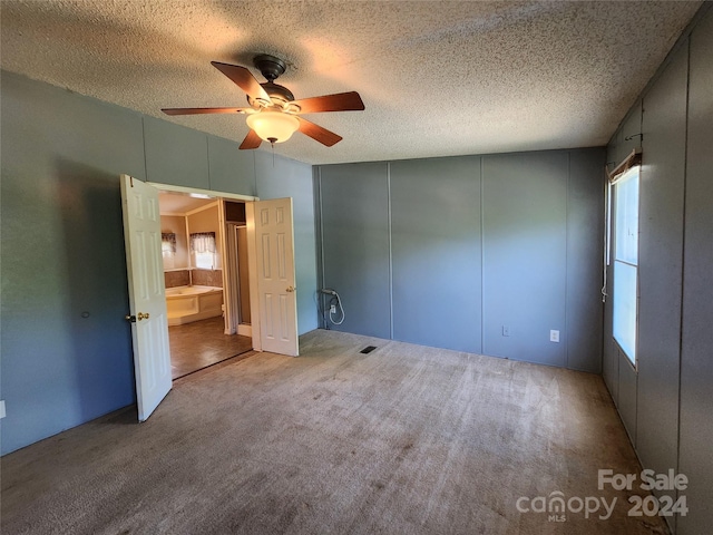 unfurnished bedroom with a textured ceiling, ceiling fan, and carpet