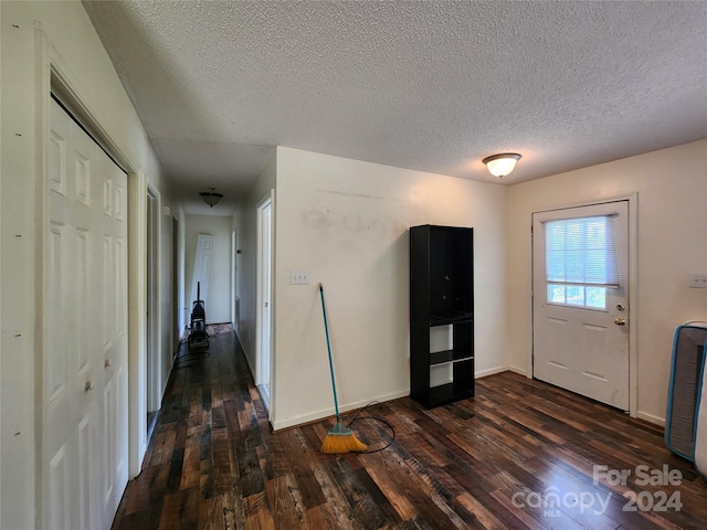 foyer featuring dark hardwood / wood-style flooring and a textured ceiling