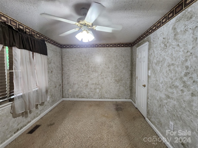 spare room with ceiling fan, carpet floors, and a textured ceiling