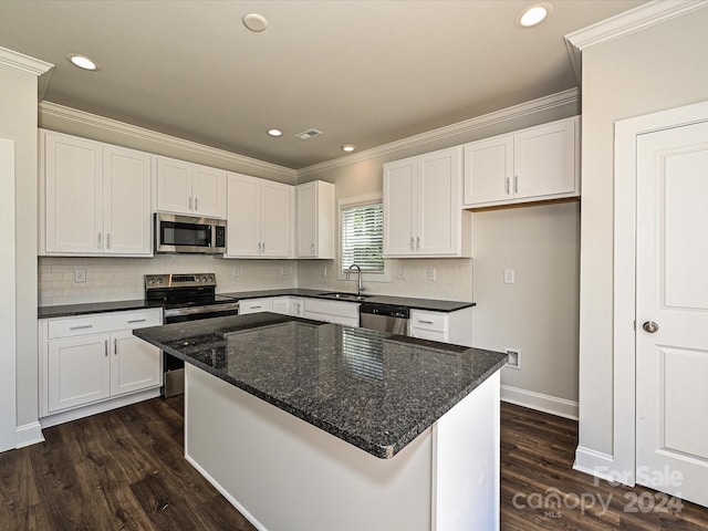 kitchen featuring a kitchen island, appliances with stainless steel finishes, white cabinets, and a sink