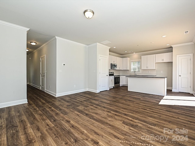 kitchen with baseboards, white cabinets, dark countertops, dark wood-type flooring, and stainless steel appliances