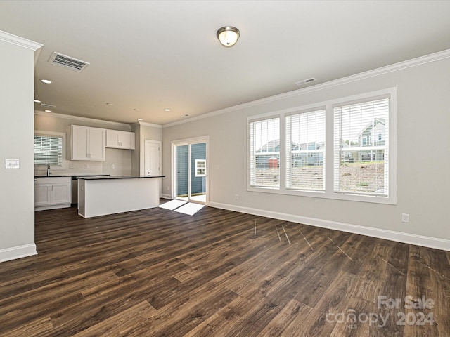 unfurnished living room featuring dark wood-style floors, visible vents, crown molding, and baseboards