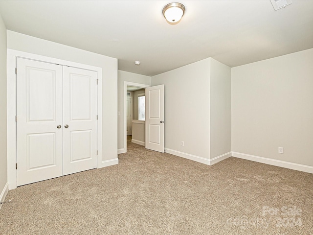 unfurnished bedroom featuring a closet, baseboards, and carpet flooring