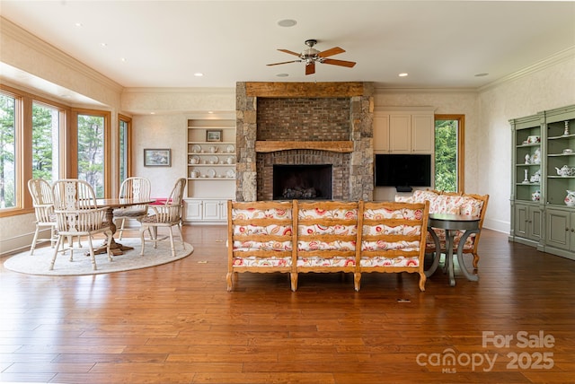 living room with ceiling fan, wood-type flooring, plenty of natural light, and crown molding