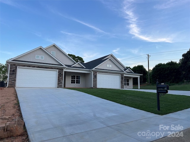 view of front of home with central AC unit, a front yard, and a garage