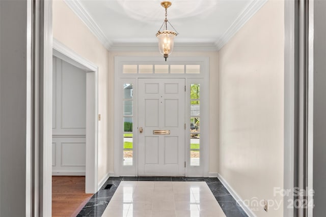 entryway featuring dark tile flooring, crown molding, and a wealth of natural light