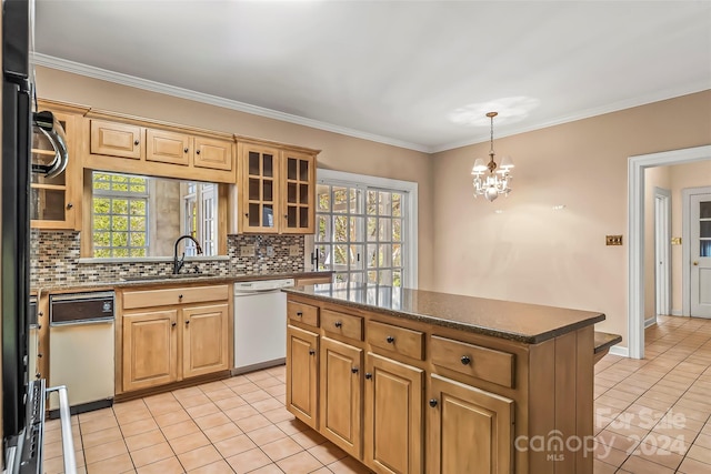 kitchen featuring white dishwasher, a kitchen island, light tile floors, sink, and an inviting chandelier