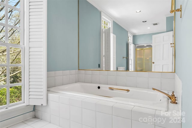 bathroom with tiled tub and tile floors