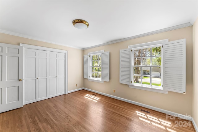 unfurnished bedroom featuring crown molding and hardwood / wood-style flooring