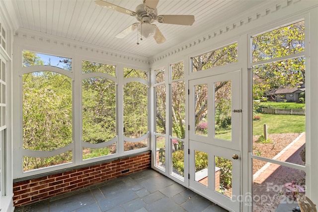 unfurnished sunroom featuring plenty of natural light, wooden ceiling, and ceiling fan