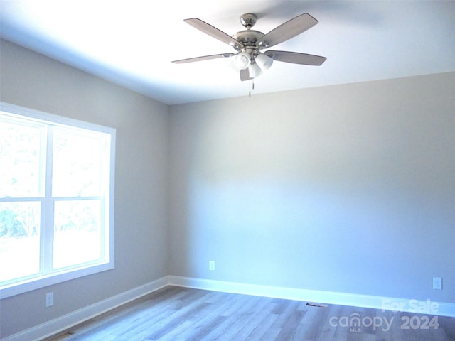 unfurnished room featuring light hardwood / wood-style flooring, plenty of natural light, and ceiling fan