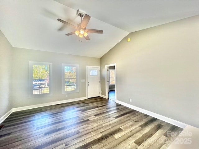 unfurnished living room with baseboards, lofted ceiling, dark wood-style floors, and a ceiling fan