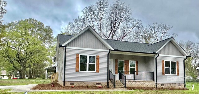 view of front facade featuring crawl space, a shingled roof, and a porch