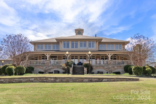 rear view of house with a porch and a lawn