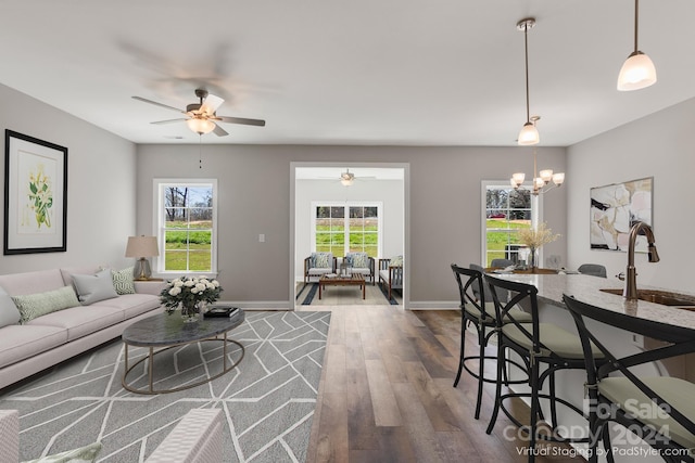 living room with sink, ceiling fan with notable chandelier, and dark hardwood / wood-style flooring