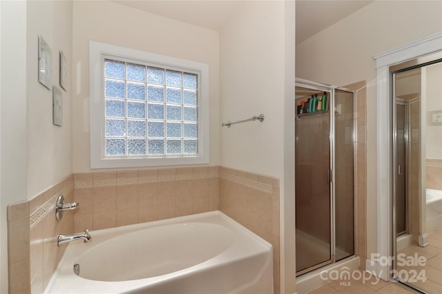 bathroom featuring tile patterned flooring and shower with separate bathtub