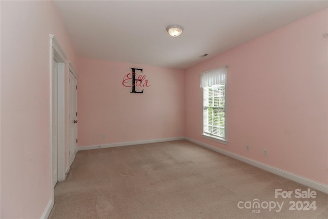 unfurnished room featuring light colored carpet