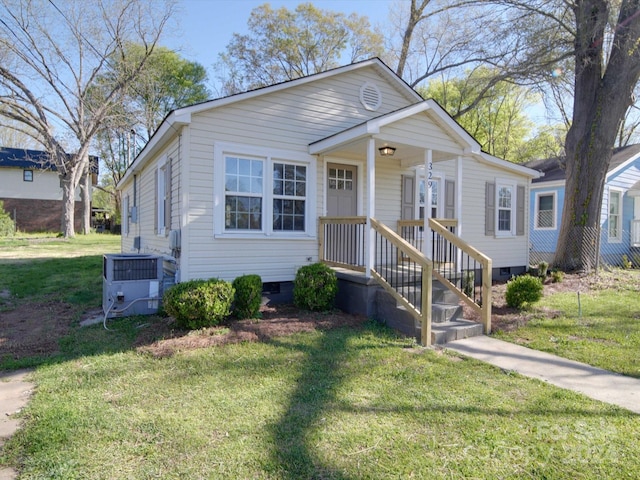 bungalow featuring central AC unit, a front lawn, and a porch