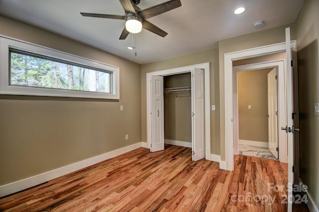 unfurnished bedroom with a closet, light hardwood / wood-style floors, and ceiling fan