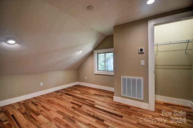 bonus room with hardwood / wood-style flooring and lofted ceiling