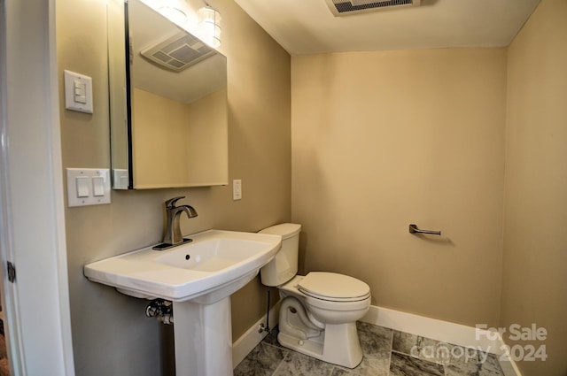 bathroom with toilet and tile floors