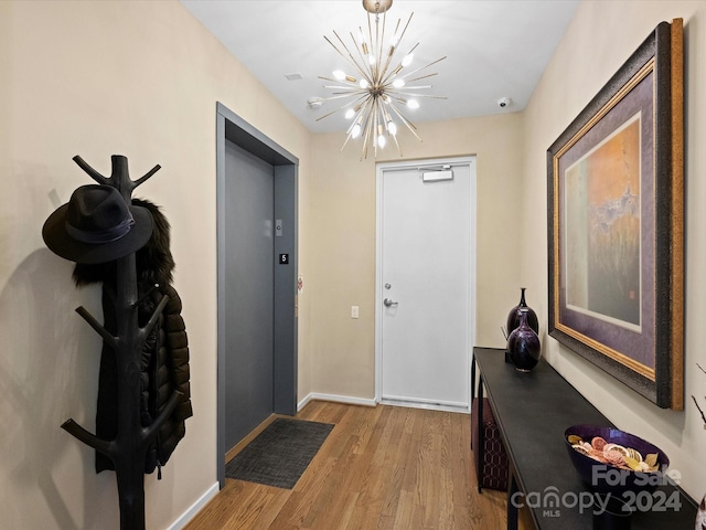 foyer entrance with light hardwood / wood-style floors and a notable chandelier