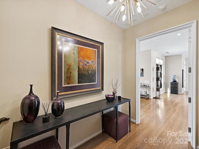 hallway featuring a notable chandelier and hardwood / wood-style flooring