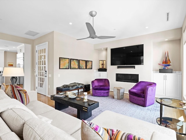 living room with wood-type flooring and ceiling fan