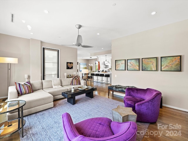 living room featuring ceiling fan and hardwood / wood-style flooring